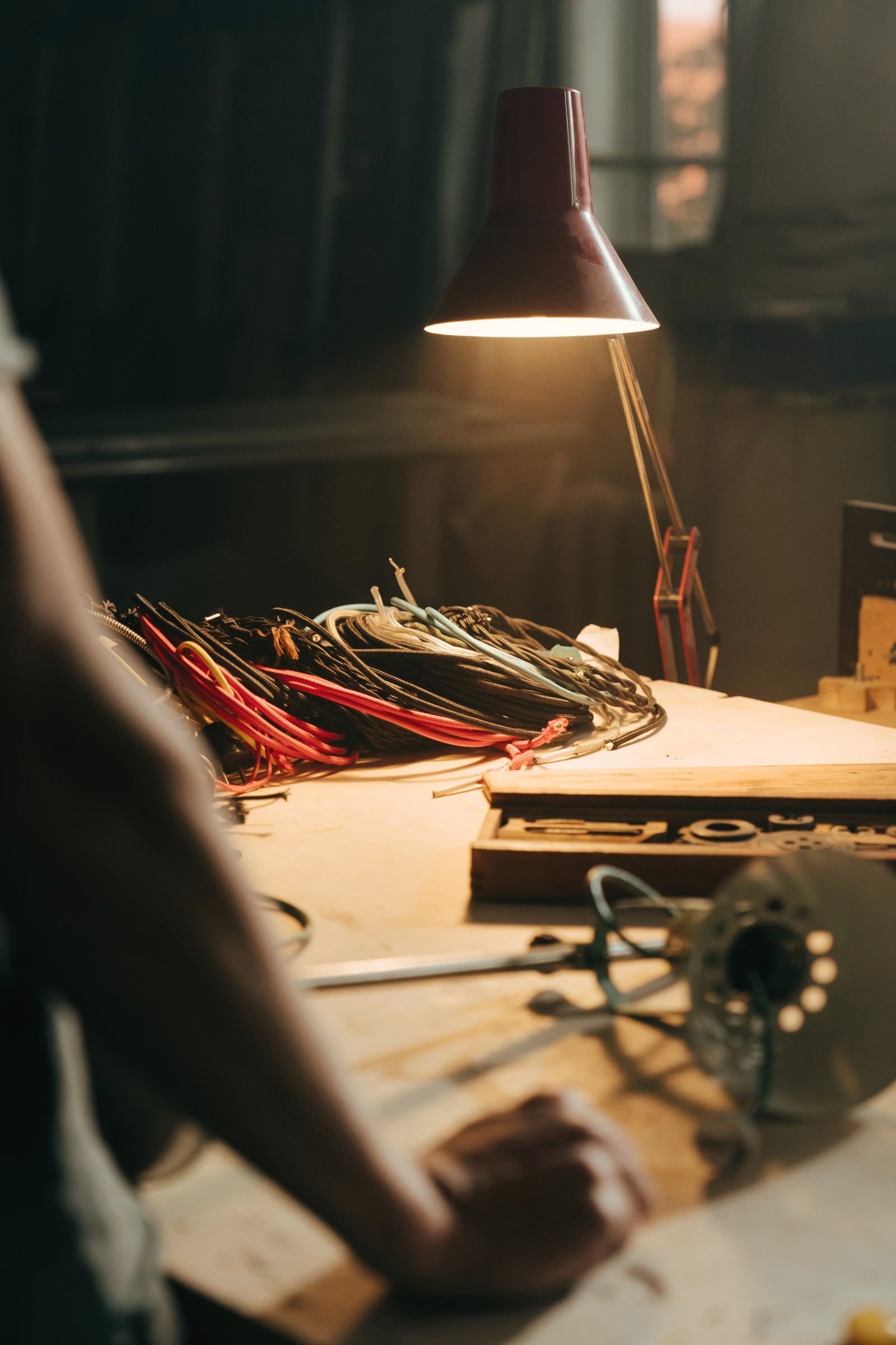 Workbench with coiled wire under a dark red task lamp
