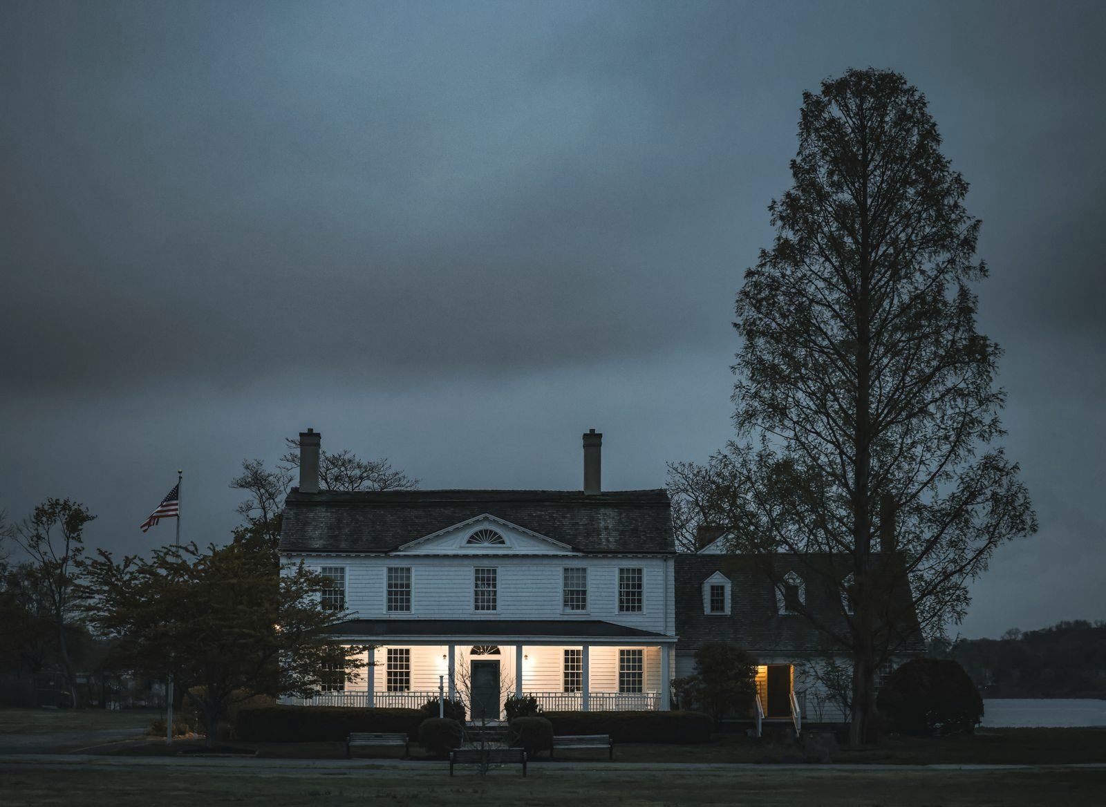 Colonial house at dusk with lit windows