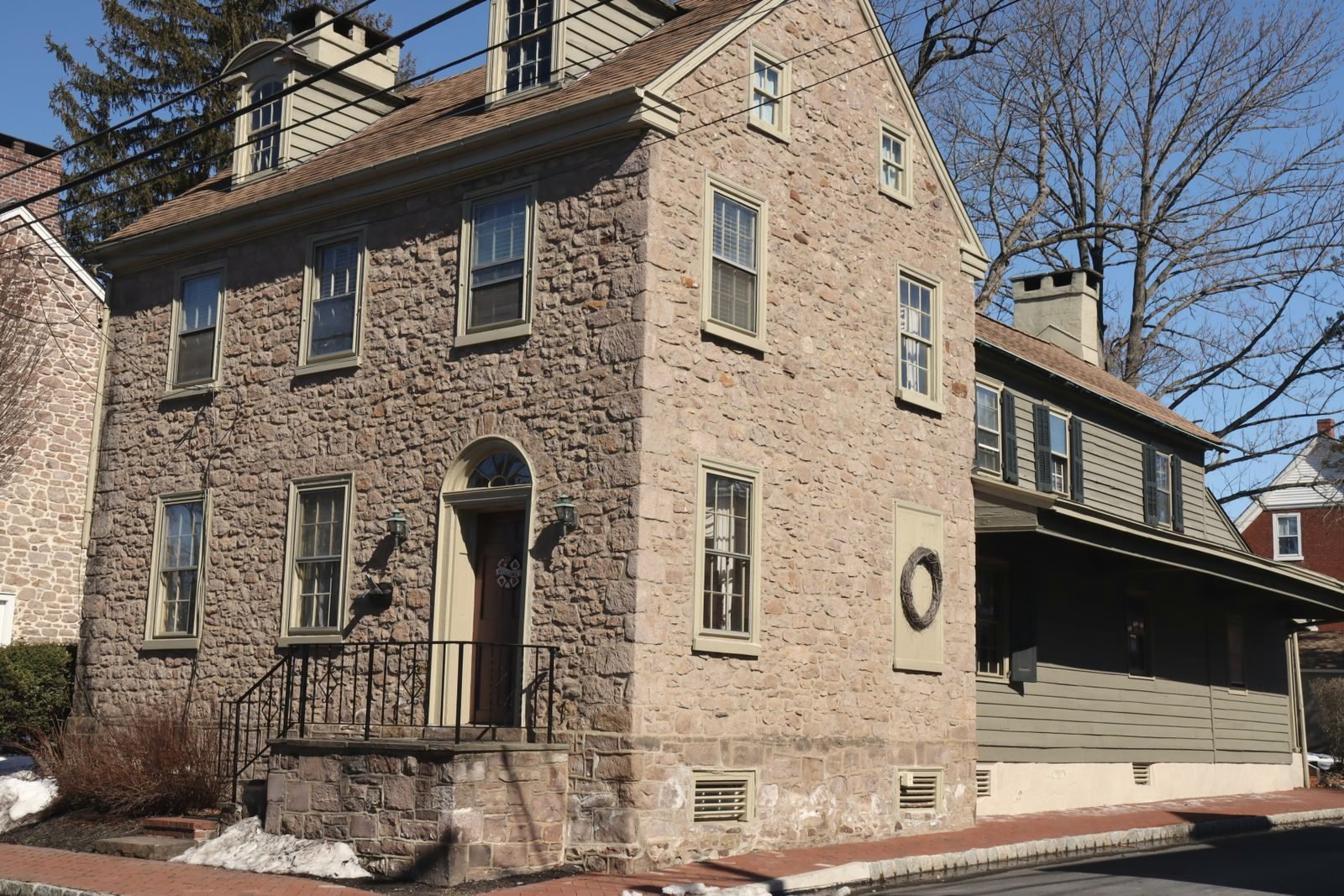 Stone colonial house on a corner with overhead service lines