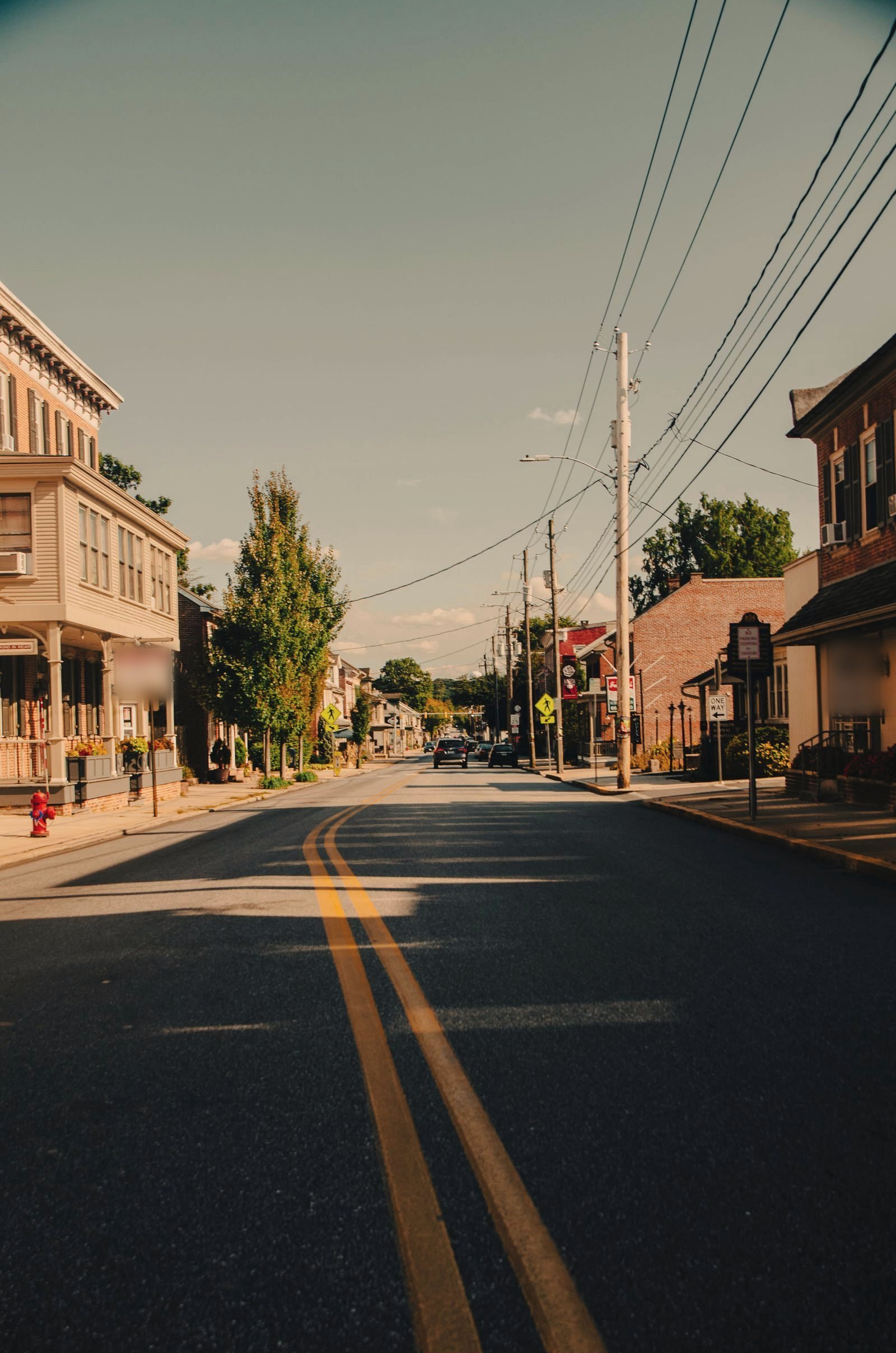 Small town main street strung with utility poles and street lights